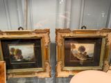 two framed paintings on the wall next to a toilet