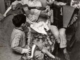 photo en noir et blanc d'un homme jouant de l'accordéon avec un groupe d'enfants