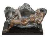 statue of a woman laying on a chair with a mirror in the background