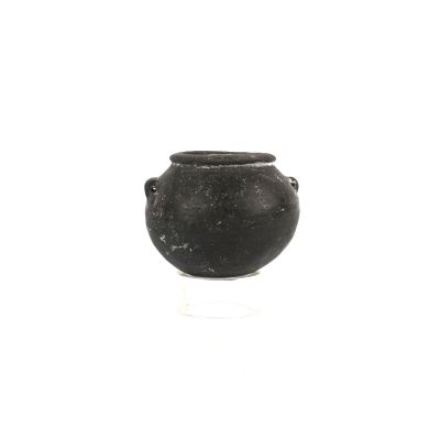 a small black pot sitting on a white surface