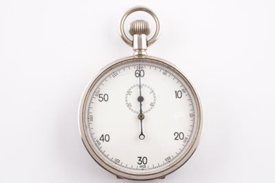 un gros plan d'une montre de poche en argent posée sur une surface blanche