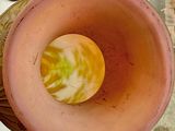 a pink vase with a yellow flower inside of it