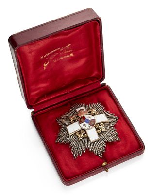 une image représentant une boîte rouge contenant une croix et une médaille