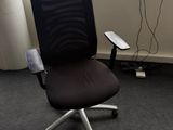 une chaise de bureau noire placée devant une fenêtre