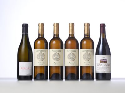 six bottles of wine are lined up on a table