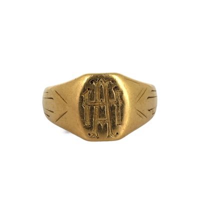 un gros plan d'une bague en or portant un monogramme
