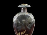 a glass bottle with writing on it on a black surface