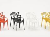 four different colored plastic chairs in a row against a white background