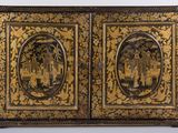 an image of a gold and black painted cabinet with two doors