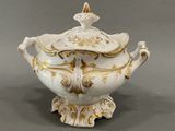 an image of a white and gold tureeny with a lid