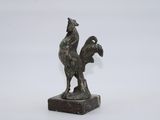 statue of a rooster on a marble base on a white background