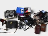 many different types of cameras and accessories laid out on the table