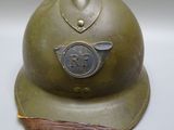 un vieux casque militaire orné d'une croix sur le côté