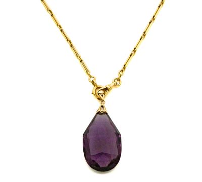 un gros plan d'un collier orné d'une pierre violette