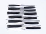 a lot of knives that are lined up on the table