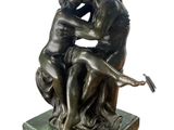 statue of a couple sitting on a marble base with a bird in the air