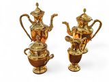 deux théières dorées et une cafetière sur fond blanc