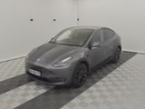 the tesla model y is parked in a garage with a checkered floor