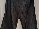 black pants hanging on a hanger in front of a white wall