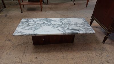 une table basse avec un plateau en marbre et un piètement en bois