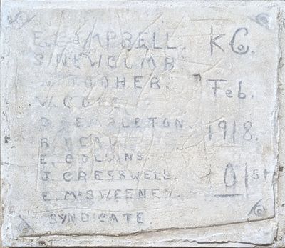une plaque en pierre apposée sur le mur d'un immeuble et sur laquelle figurent des inscriptions