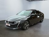 La voiture noire est garée dans une grande pièce aux murs blancs.