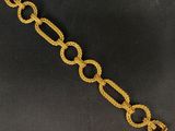 gros plan d'un bracelet en chaîne en or sur fond noir