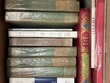 many books in a box that are stacked together