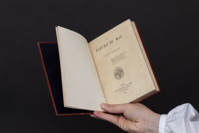 une personne tient un livre ouvert à la main sur un fond noir