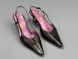 a pair of black and pink shoes on a grey surface