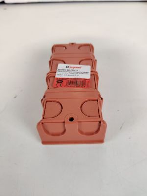 une petite boîte en plastique orange sur laquelle est collée une étiquette