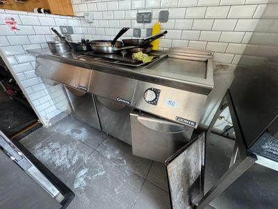 une cuisine équipée d'une cuisinière, d'un évier et d'autres appareils électroménagers