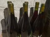 several bottles of wine are lined up on a table in front of a brick wall