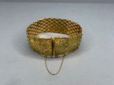 a close up of a gold bracelet with a chain around it