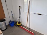 a broom and broom brush in the corner of a room