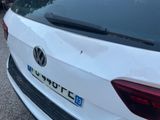a close up of a white volkswagen car parked on the side of the road