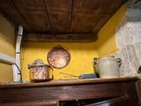 pots and pans sitting on a shelf in the corner of a room