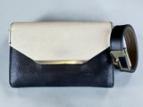 a black and white purse with a gold buckle on it