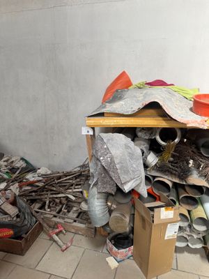 un tas d'ordures dans un coin d'une pièce, près d'un mur
