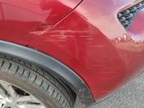 un gros plan d'une voiture rouge avec un chat sur le côté