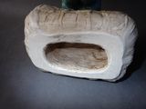 a figurine of a cat sitting on a rock