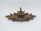 an antique brass plate with a pagoda on top