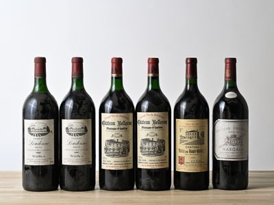 several bottles of wine are lined up on a wooden table