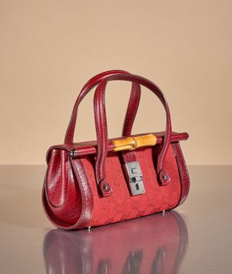 a red purse sitting on a table with a yellow handle