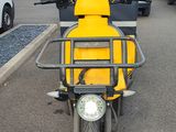 a yellow scooter that is parked in a parking lot