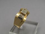 an image of a gold and diamond ring on a clear stand