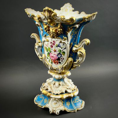 a blue and gold vase with flowers on it