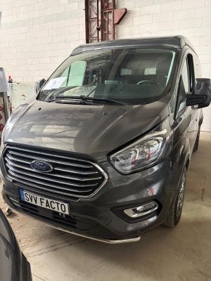 l'avant d'une camionnette grise garée dans un garage à côté d'autres voitures