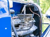 a close up of a car engine with a blue car in the background