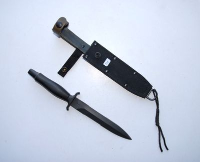 a knife and a knife holder on a white surface